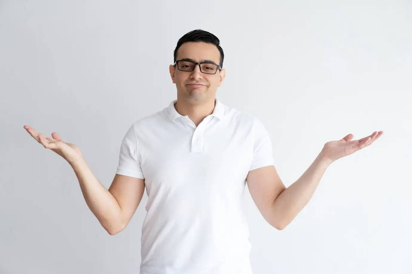 Ein verunsicherter junger Mann wirft die Hände hoch und blickt in die Kamera.