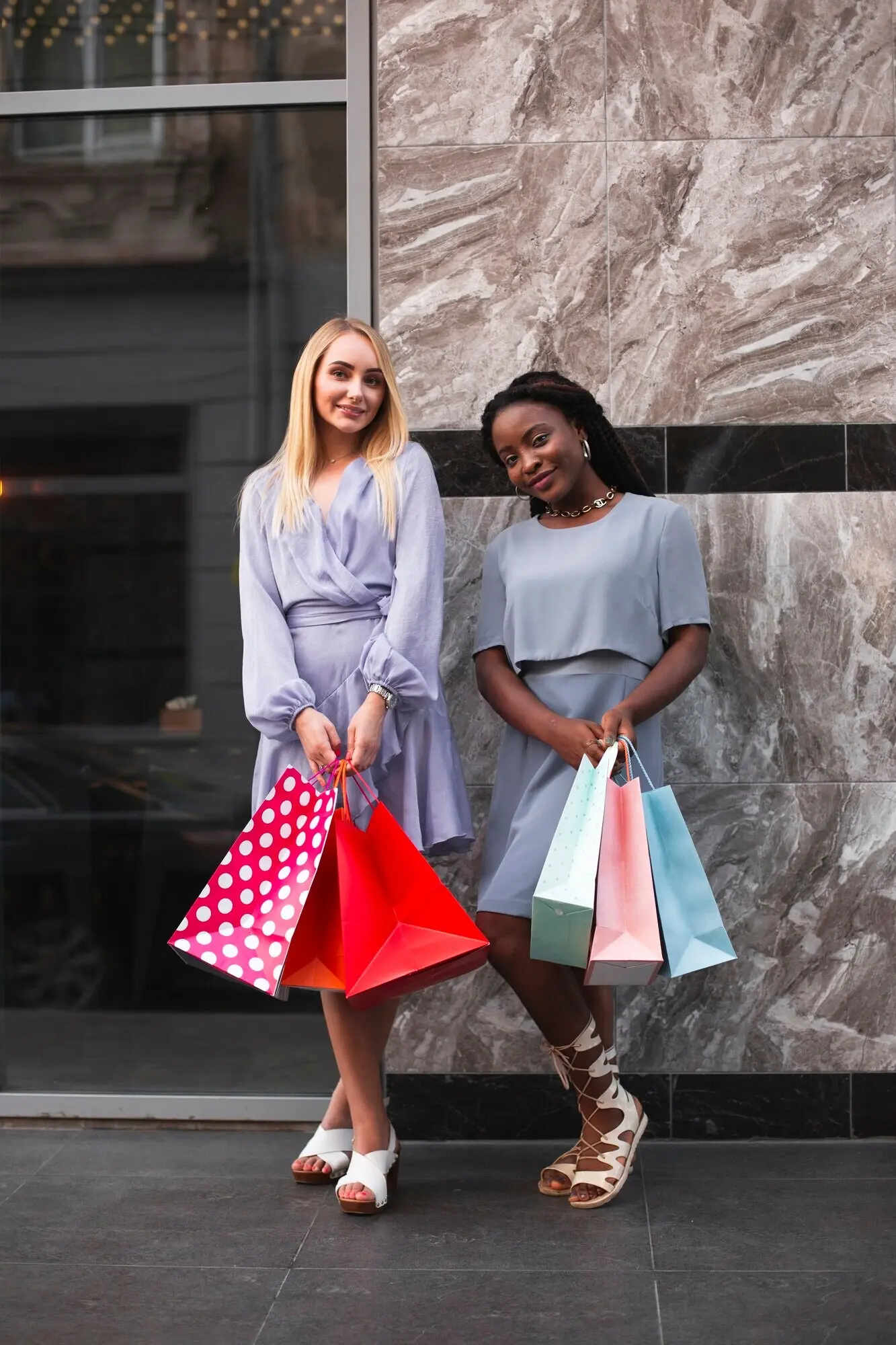 Frauen mit Einkaufstaschen blicken in die Kamera.